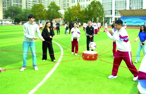 学校操场上,中法师生一起做游戏